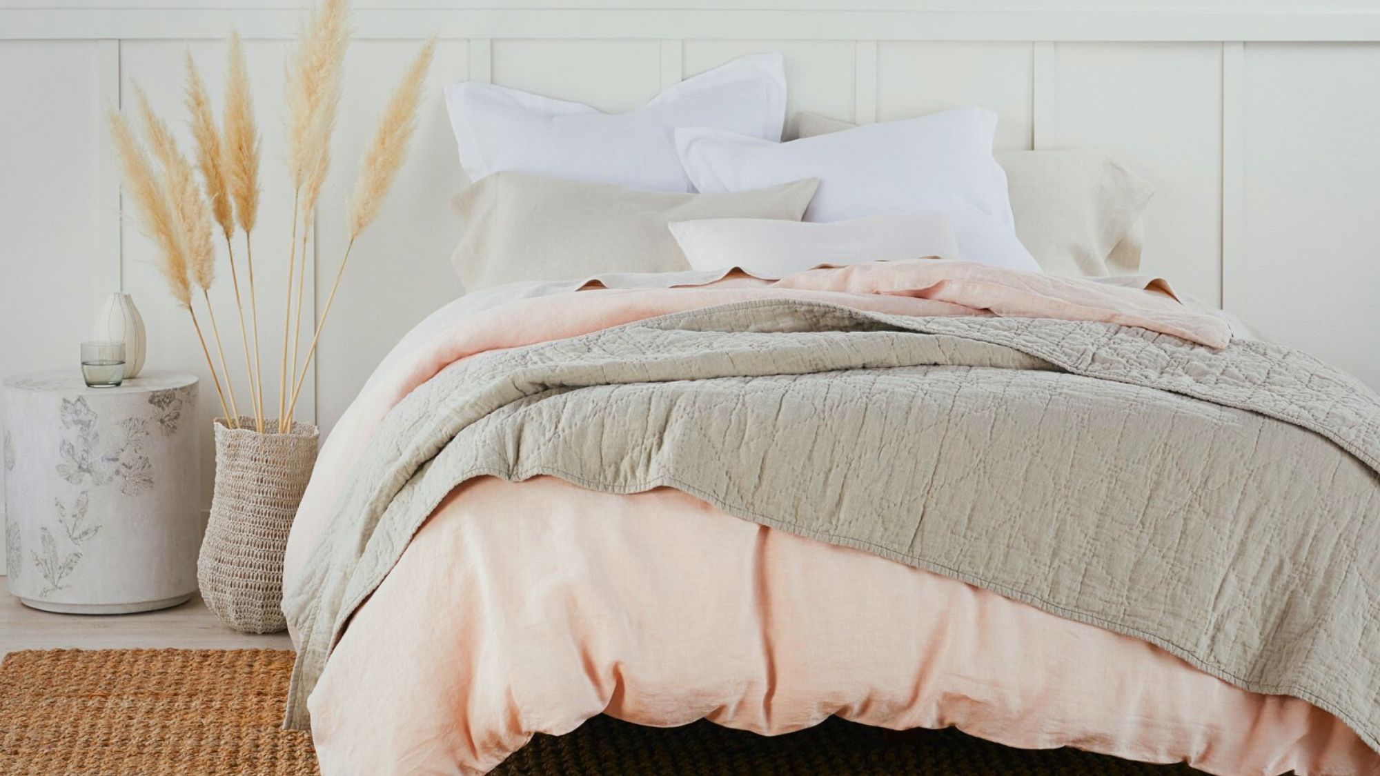 A cozy winter luxury bedding with a pink and gray comforter and pillows
