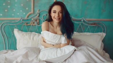 A girl sitting and smiling on a luxury bedding