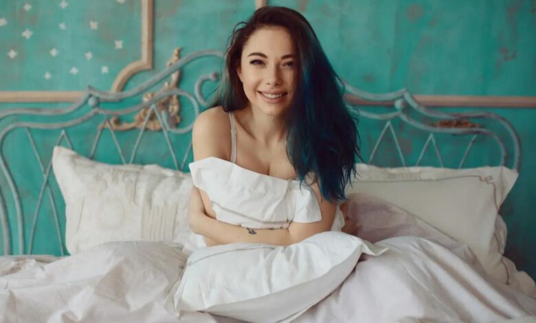 A girl sitting and smiling on a luxury bedding